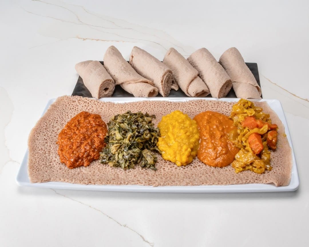 Ethiopian vegetarian combo — lentils, split peas, greens, and vegetables on injera